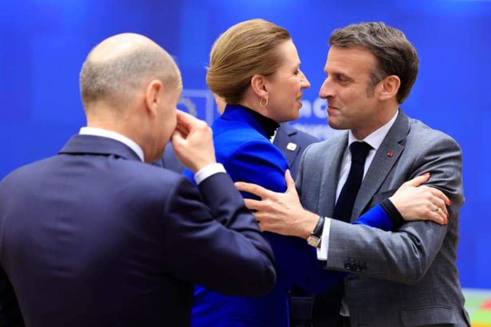Den franske præsident Macron hilsner på statsminister Mette Frederiksen (S) ved topmødet, mens den tyske kansler Scholz ser på.Foto: Geert Vanden Wijngaert/Ritzau Scanpix